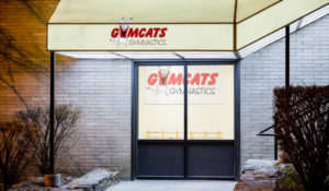 A gym with a door that says gymcats gymnastics.