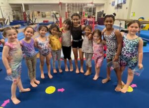 A group of young girls standing in front of an obstacle course.